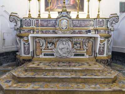 L'altare centrale � invece caratterizzato da fastosi intarsi marmorei. Sul grande tavolo sono adagiati sei candelabri e una croce, tutti dorati...